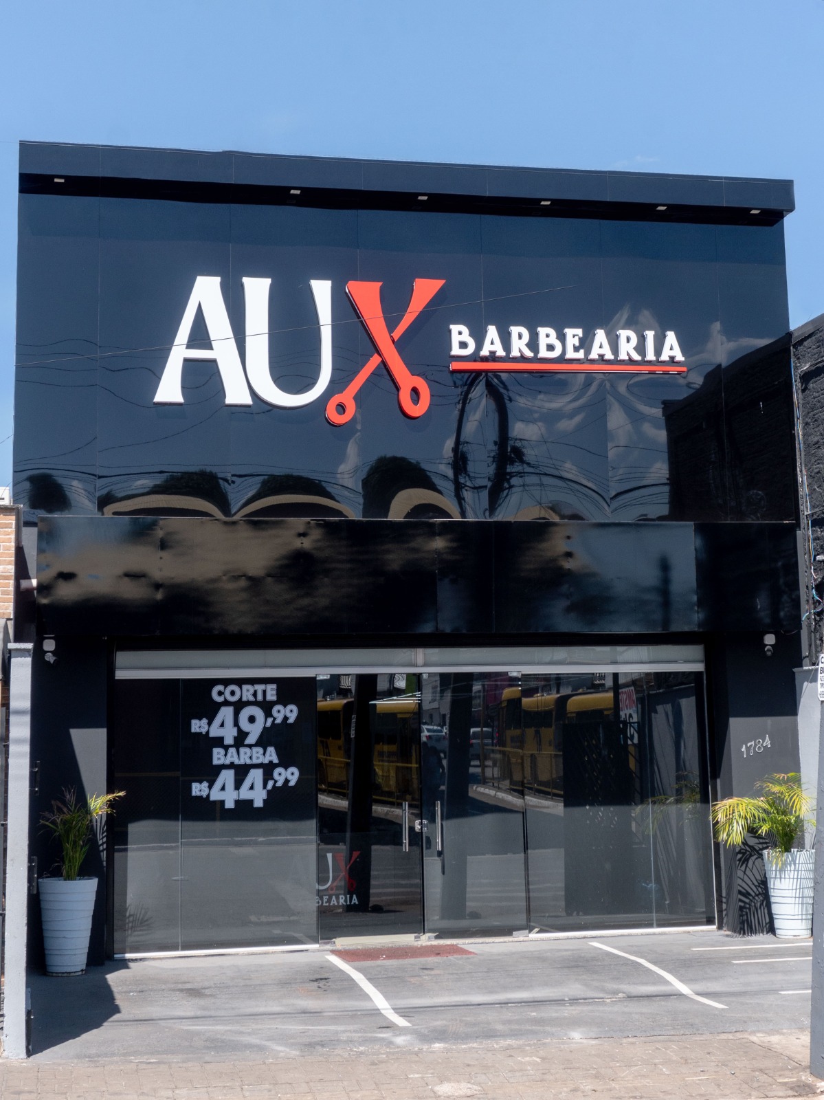 Fachada da AUX Barbearia em Araguaína com letreiro iluminado