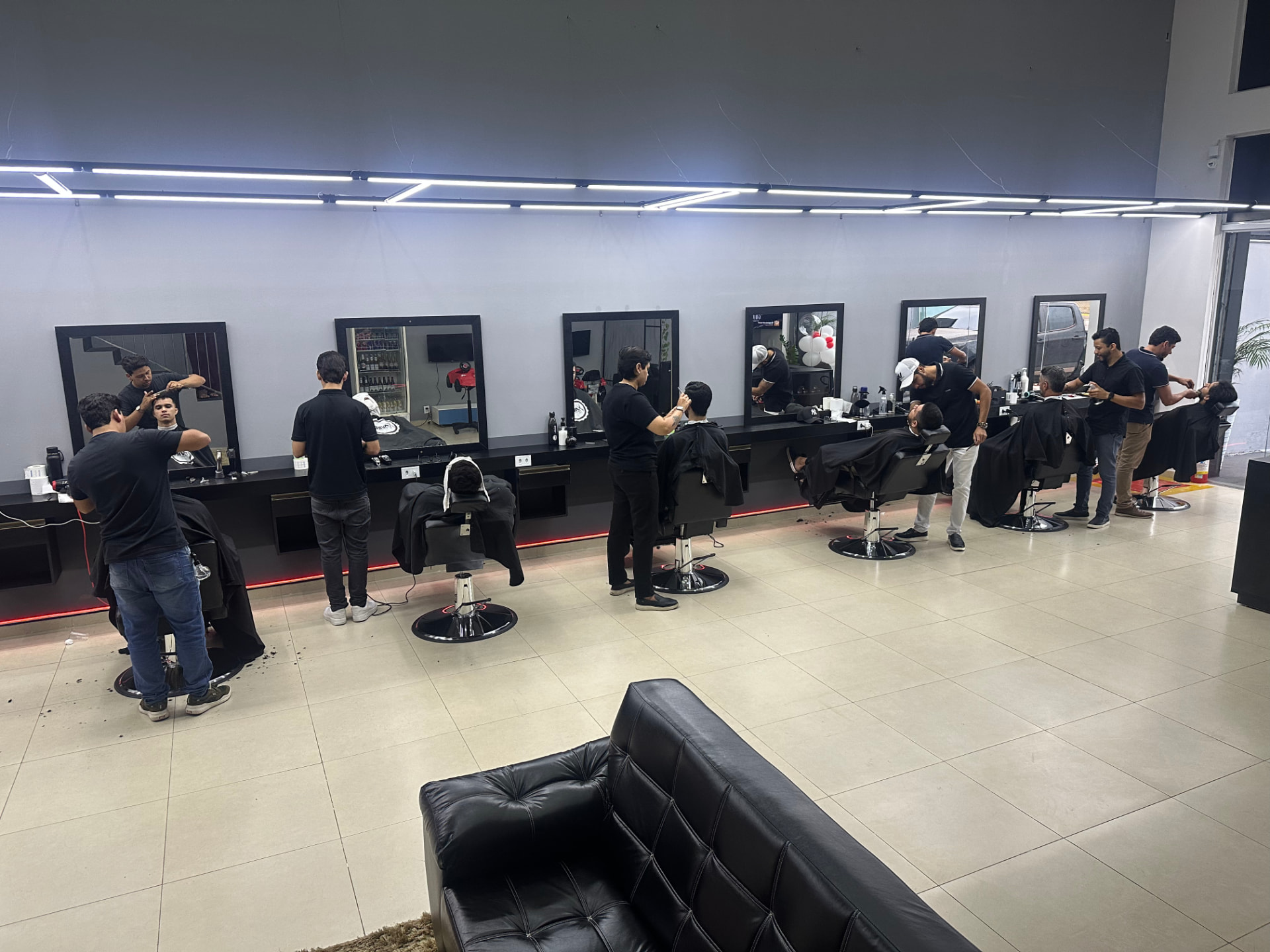 Interior da AUX Barbearia com cadeiras de barbeiro em fileira